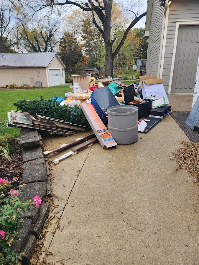 Dumpster being loaded with debris for Estate Cleanout Dumpster Rental in Menands